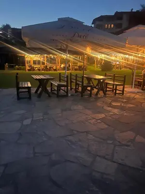 a group of picnic tables and benches in front of a building at SPA Hotel Daffi in Smolyan