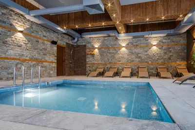 a pool in a building with chairs around it at SPA Hotel Daffi in Smolyan