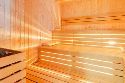 a sauna with wooden paneled walls and wooden stairs at SPA Hotel Daffi in Smolyan