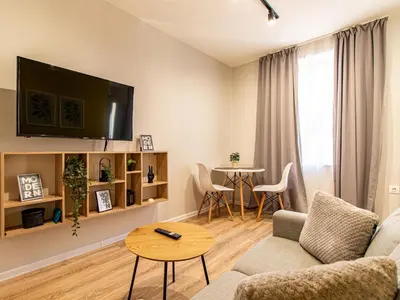 a living room with a couch and a table at Trocadero Touch: Sofia Hideaway in Sofia