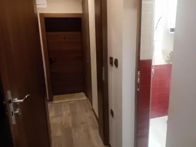 a hallway with a door and a bathroom with a shower at Кръчмъ При Байката апарт in Teteven
