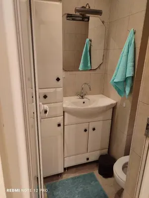 a bathroom with a sink and a mirror and a toilet at Апартамент ВалАнди in Samokov