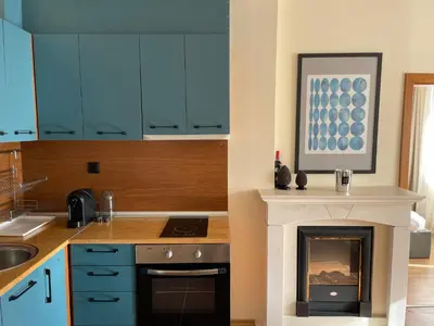 a kitchen with blue cabinets and a fireplace at LHApartment! in Pamporovo