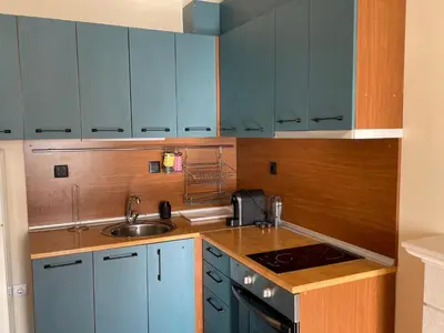 a kitchen with blue cabinets and a sink at LHApartment! in Pamporovo