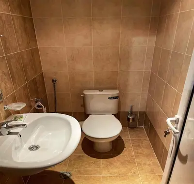 a bathroom with a white toilet and a sink at LHApartment! in Pamporovo