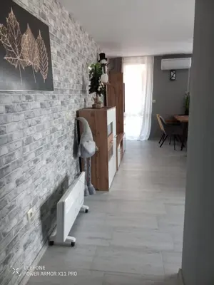 a living room with a brick wall and a hallway at Royal Park Bansko premium in Bansko