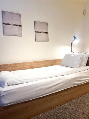 a bed in a room with two pictures on the wall at Elite Apartments Complex Iglika Borovets in Borovets