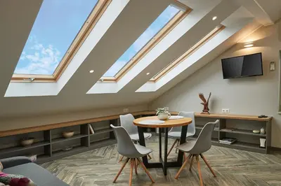 a room with a table and chairs and skylights at Lofty - 1 bedroom apartment in the heart of Sofia in Sofia