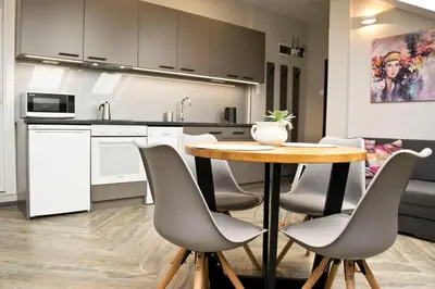 a kitchen with a table and chairs in a room at Lofty - 1 bedroom apartment in the heart of Sofia in Sofia