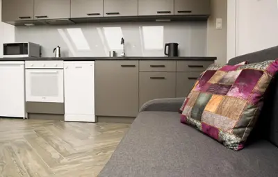a living room with a couch and a kitchen at Lofty - 1 bedroom apartment in the heart of Sofia in Sofia