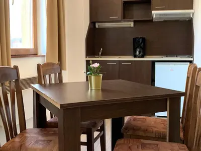 a kitchen with a wooden table with a vase on it at Banderitsa Apartment 2 in Bansko