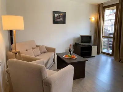 a living room with a couch and a tv at Banderitsa Apartment 3 in Bansko