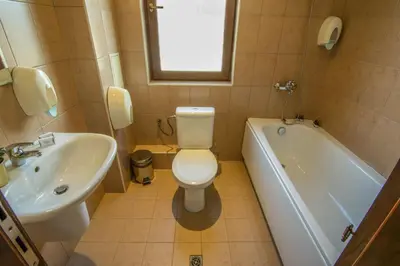 a bathroom with a toilet and a sink and a tub at Banderitsa Apartment 3 in Bansko