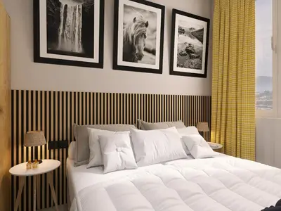 a bedroom with a large white bed with pictures on the wall at Hotel Etropol, Center Etropole in Etropole