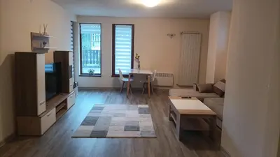 a living room with a couch and a tv at Bron's Suite in Pamporovo