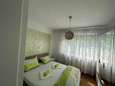 a bedroom with a bed and a window at Апартаменти Viviana in Plovdiv