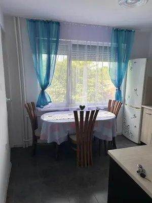 a kitchen with a table with chairs and a window at Апартаменти Viviana in Plovdiv
