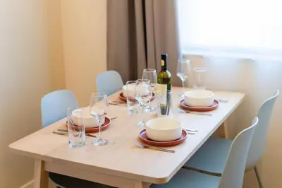 a table with glasses and a bottle of wine on it at Design 1BDR Apartment near City Center in Sofia