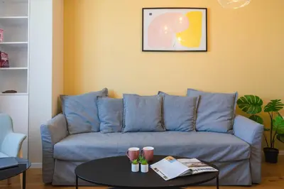 a living room with a blue couch and a table at Design 1BDR Apartment near City Center in Sofia
