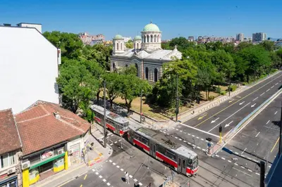 a bus driving down a street in a city at Design 1BDR Apartment near City Center in Sofia