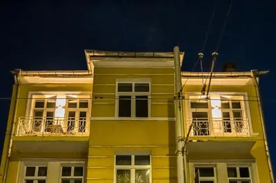 a yellow building with windows and balconies at night at North 21 - Brand New Modern 1BD Apt in Sofia Center by Flat Mаnager in Sofia