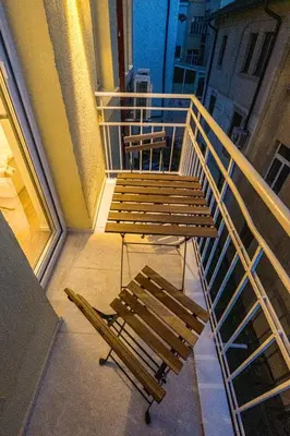 a balcony with two wooden benches and a table at South 22 - Brand New Modern 1BD Apt in Sofia Center by Flat Mаnager in Sofia