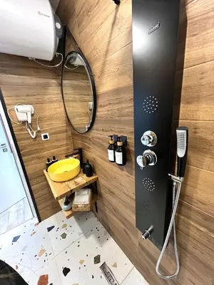 a bathroom with a shower and a yellow sink at Stracciatella Homes Apartment in Sofia