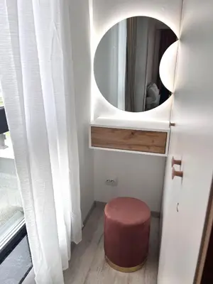 a bathroom with a round mirror and a stool at Stracciatella Homes Apartment in Sofia