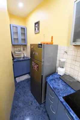 a small kitchen with a refrigerator and blue counters at INB Iconic Spot in Sofia