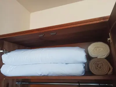 a group of pillows and towels on a shelf at Sunrise View with Free SPA and Bottle of Wine in Cornelia Deluxe Residence, free Parking in Bansko