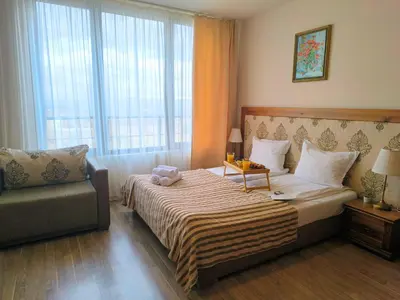 a hotel room with a bed and a chair at Sunrise View with Free SPA and Bottle of Wine in Cornelia Deluxe Residence, free Parking in Bansko