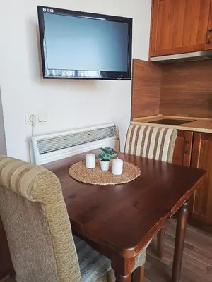 a living room with a wooden table and a tv at Sunrise View with Free SPA and Bottle of Wine in Cornelia Deluxe Residence, free Parking in Bansko