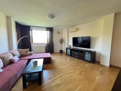 a living room with a couch and a flat screen tv at Pravets Lake Panorama Apartments in Pravets