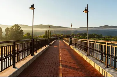 a bridge with street lights and a brick walkway at Pravets Lake Panorama Apartments in Pravets