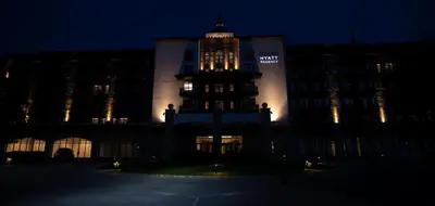 a large building with a clock tower at night at Pravets Lake Panorama Apartments in Pravets