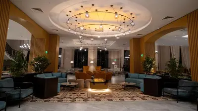 a lobby with blue chairs and a chandelier at Pravets Lake Panorama Apartments in Pravets