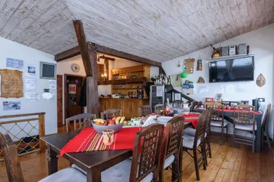 a dining room with a red table and chairs at Chalet Garibaldi - Total Chalets in Bansko