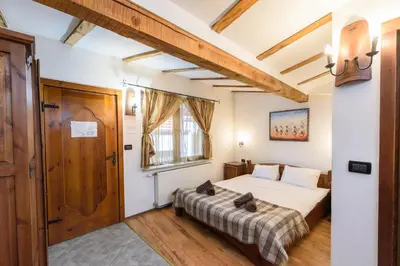 a bedroom with a bed with a cat sitting on it at Chalet Garibaldi - Total Chalets in Bansko