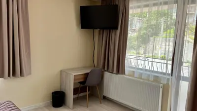 a room with a desk and a window with a television at Къща за гости Михаела in Chepelare