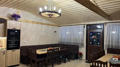 a dining room with a table and chairs and a chandelier at Къща за гости Михаела in Chepelare