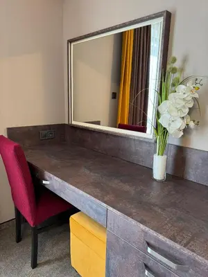 a desk with a mirror and a vase of flowers at Стоичковата къща гр. Стрелча in Strelcha