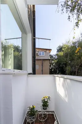 a balcony with two tables and a window with flowers at S íRMA Apartment - The Diamond of Sofia in Sofia