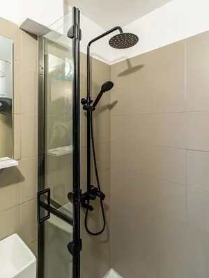 a shower in a bathroom with a glass door at Eagle's Nest - Sofia Central Studio in Sofia