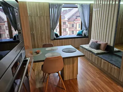 a small kitchen with a table and a chair at Стаята на Ив in Bansko