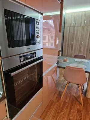 a kitchen with a microwave and a table with a chair at Стаята на Ив in Bansko