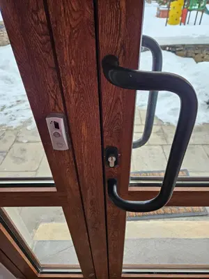 a wooden door with a black handle on a window at Стаята на Ив in Bansko
