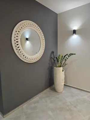 a mirror on a wall with a plant in a vase at Стаята на Ив in Bansko