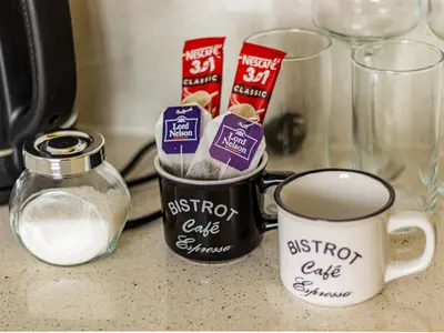 a counter top with a cup of coffee and a jar of milk at Nevsky Loft - Central Sofia Studio in Sofia