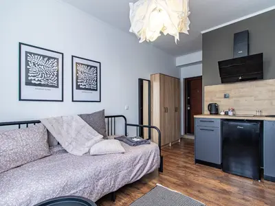 a living room with a couch and a kitchen at Vitosha Loft - Central Sofia Studio in Sofia