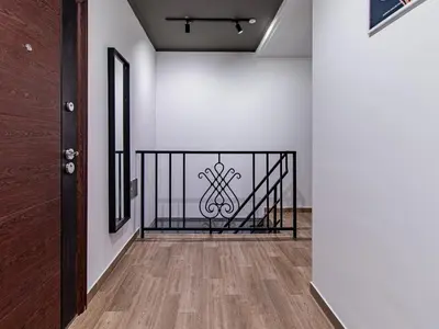 a hallway with a black iron railing and white walls at Serdika Loft - Central Sofia Studio in Sofia